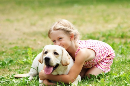 How Your Children Can Play With Your Dog Safely a little blond girl with her pet dog outdooors in park